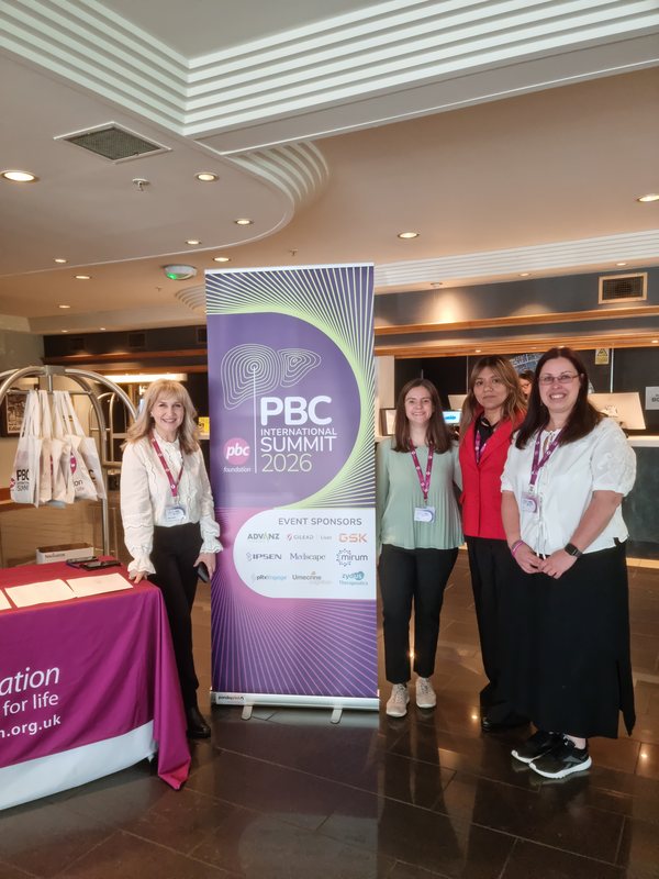 Representantes de organizaciones de pacientes junto al banner del PBC International Summit 2026