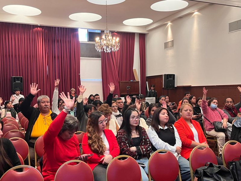 Asistentes participan levantando la mano durante la jornada